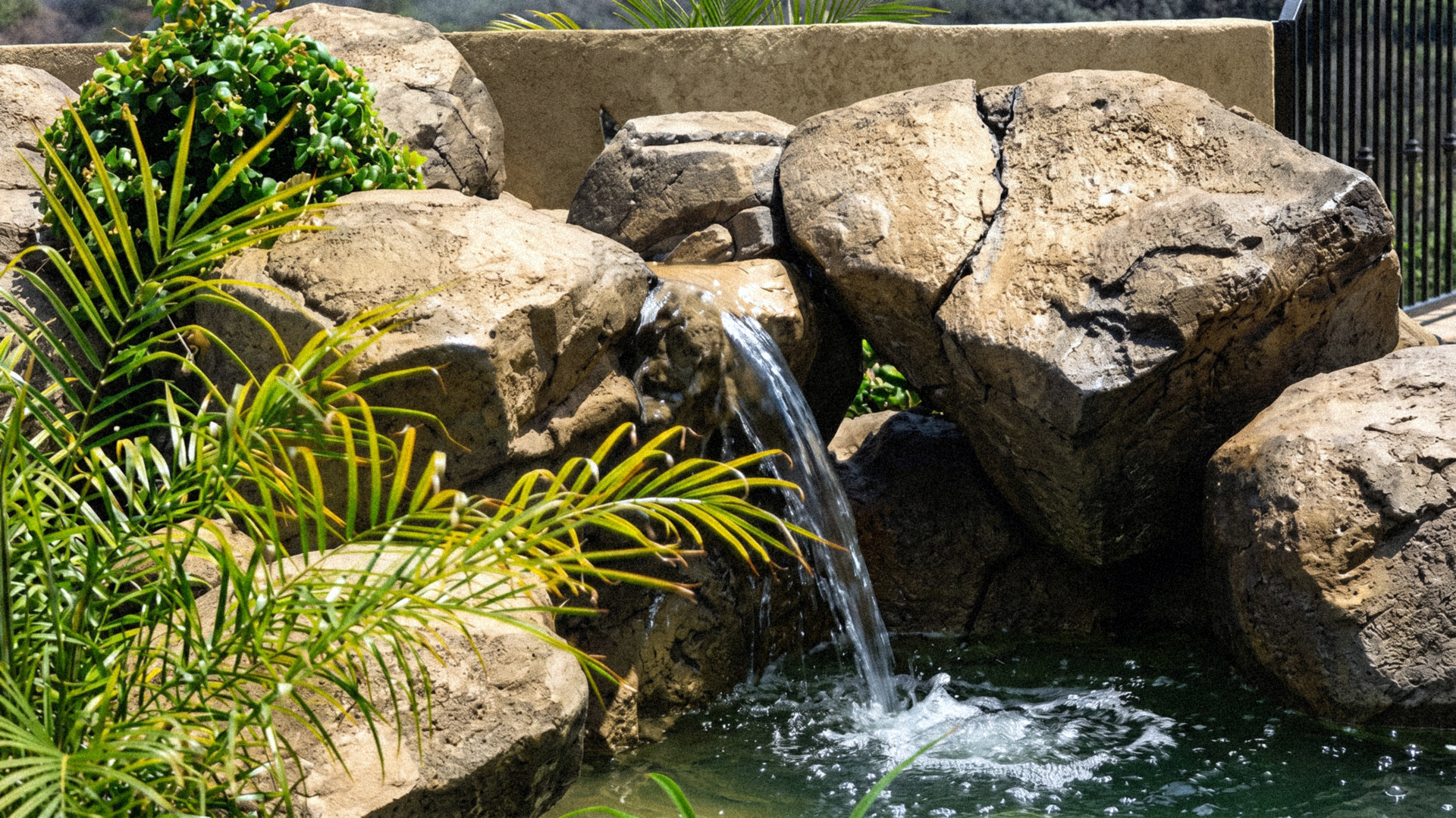 small artificial  rock waterfall fountain in front yard